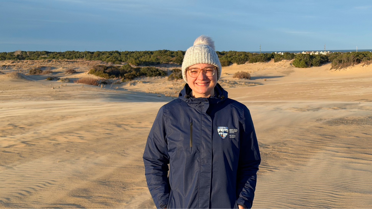 Image shows Sarah Grace smiling at Jockey's Ridge.
