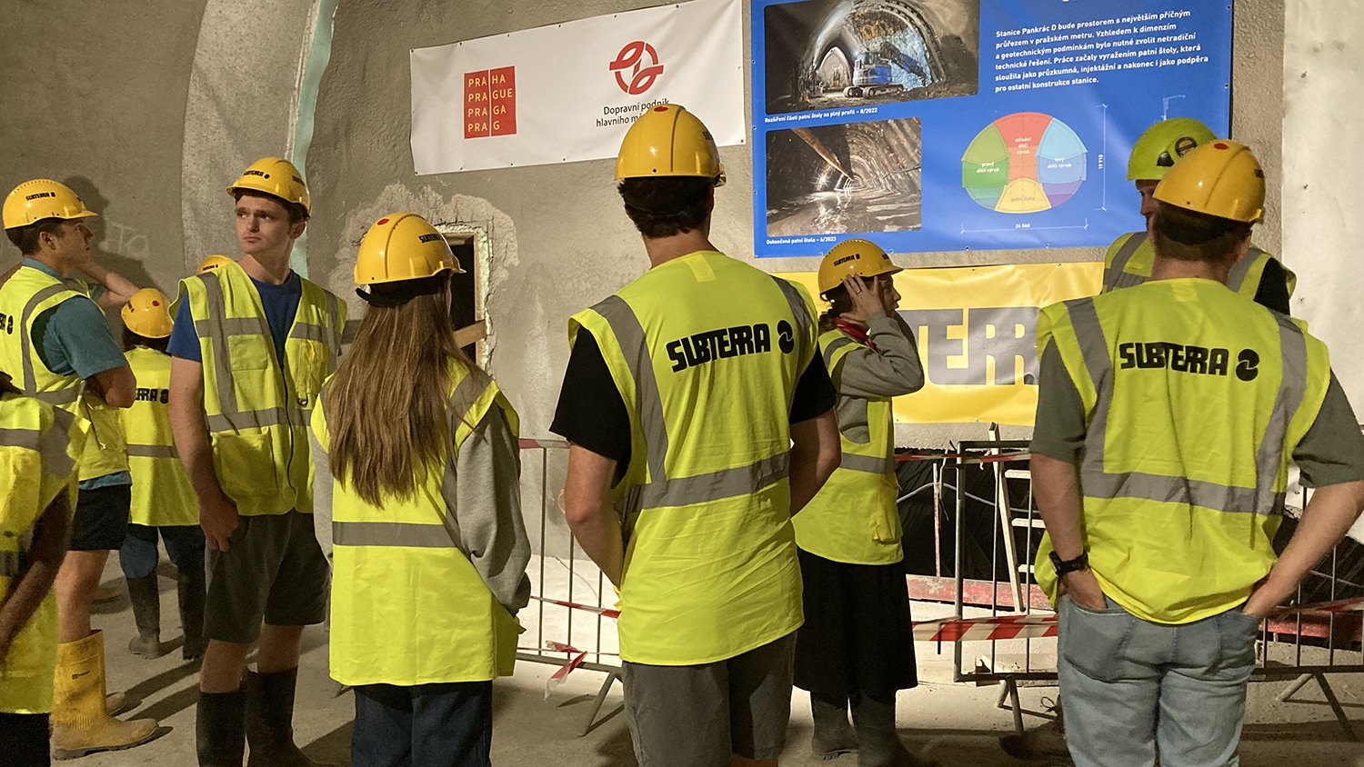 Image shows a group of students in hard hats and bright yellow vests.
